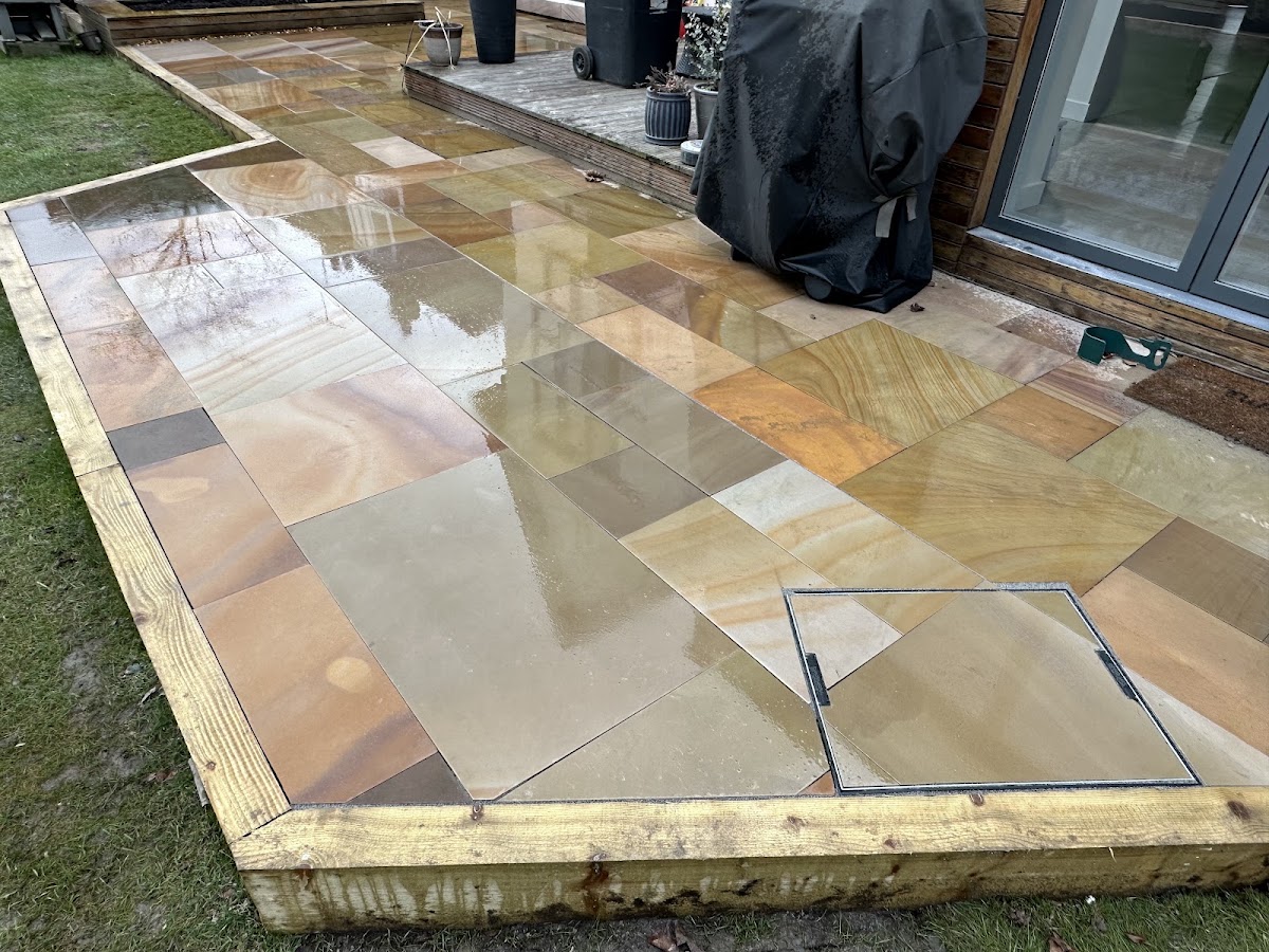 Sandstone paving with a sleeper edge and an inset access hatch