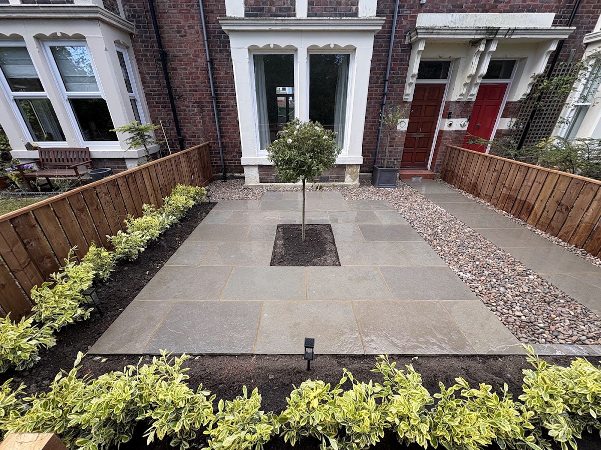 Front garden in Blyth with sandstone paving, a central tree, cobble strip and new planting